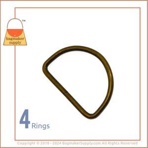 May include: Four antique brass D-rings. The rings are approximately 1 inch in diameter.