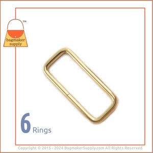 May include: Six gold-toned metal rings, each with a rectangular shape. The rings are ideal for attaching to straps, handles, or other accessories.