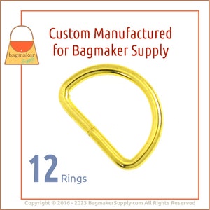 May include: A gold-colored D-ring, a half-circle shape, is displayed against a white background. The image includes the text "Custom Manufactured for Bagmaker Supply" and "12 Rings."