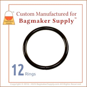 May include: A close-up of twelve black metal rings. The rings are 1 inch in diameter and are ideal for making bags and other crafts.