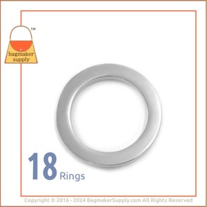 May include: A pack of 18 silver metal rings. The rings are round and have a smooth finish. They are perfect for making jewelry or other crafts.