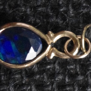 Peut inclure: Une boucle d'oreille en or avec une pierre précieuse bleue en forme de larme.