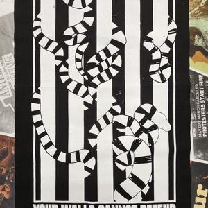 Puede incluir: Parche gráfico en blanco y negro con el texto "YOUR SHACKLES WILL NOT HOLD, JAILOR" y "YOUR WALLS CANNOT DEFEND". El diseño presenta rayas verticales y formas segmentadas.