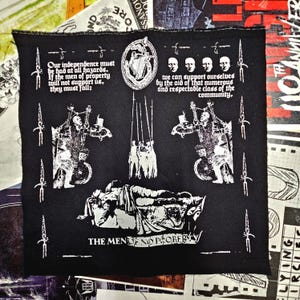 Pode incluir: Patch de tecido preto com ilustrações e texto brancos. O design inclui figuras, espadas e texto que diz "Our independence must be had at all hazards..." e "THE MEN OF NO PROPERTY."
