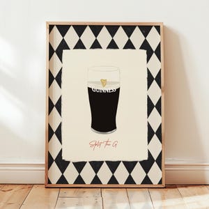 May include: A framed print of a pint of Guinness. The image shows a glass of the dark stout with the Guinness logo. The print has a cream background with a black and white diamond pattern border. The text "Split the G" is below the glass of stout.