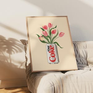 K&ouml;nnte beinhalten: Gerahmter Kunstdruck mit einer Diet Coke-Dose, die mit rosa Tulpen gef&uuml;llt ist. Die Dose ist wei&szlig; mit roter Schrift, und die Blumen haben gr&uuml;ne Stiele und Bl&auml;tter. Der Hintergrund ist hellbeige.