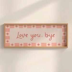 Puede incluir: Una impresi&oacute;n art&iacute;stica rectangular enmarcada en madera con las palabras "Love you. bye" en un estilo manuscrito. La impresi&oacute;n tiene un borde a cuadros rosa claro y blanco con acentos de estrellas.