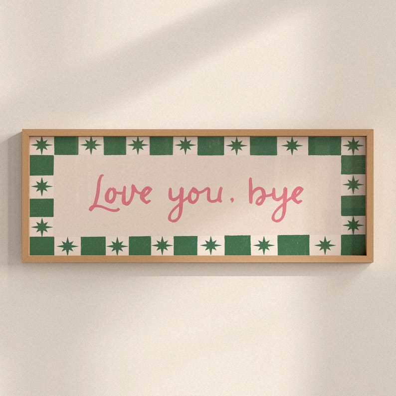 Puede incluir: Un letrero rectangular con marco de madera con las palabras "Love you. bye" en escritura rosa. El letrero tiene un fondo blanco con un borde verde y estrellado.