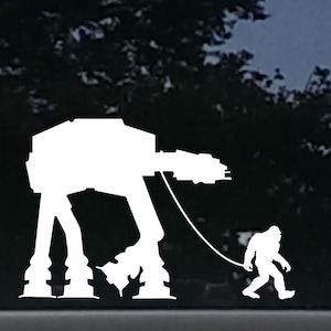 May include: A white silhouette of a Star Wars AT-AT walker being walked by a Bigfoot on a leash. The image is on a black background.