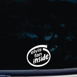 Puede incluir: Pegatina de vinilo blanco con el texto "Elvis fan inside" en una forma ovalada redondeada.