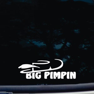 以下が含まれることがあります： 雪上バイクのシルエットと「BIG PIMPIN」というテキストが入った白いビニールステッカーです。