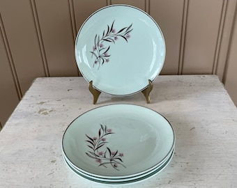 May include: Set of four vintage salad plates with a delicate floral design in shades of pink and green on a light blue background.
