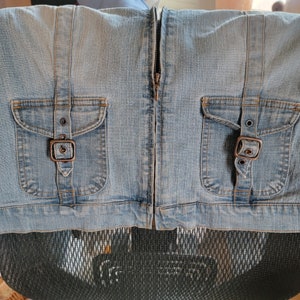 May include: A light blue denim skirt with two pockets and a zipper closure. The pockets have metal buckles.