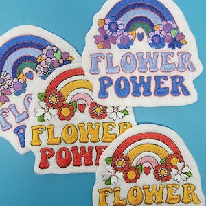 May include: Three embroidered iron-on patches with a rainbow and flowers. Each patch says "Flower Power" in colorful letters.