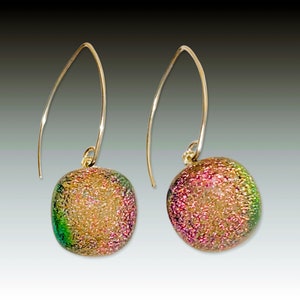 Pode incluir: Um par de brincos de argola de ouro com contas de vidro iridescentes. As contas têm uma superfície texturizada e um esquema de cores rosa, verde e dourado.