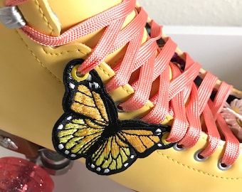 May include: Yellow roller skates with pink laces and a butterfly patch on the side. The wheels are pink with glitter.