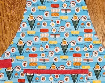 May include: A red and blue apron with a pocket and adjustable straps. The apron is covered in a pattern of different types of sushi, including nigiri, maki, sashimi, temaki, and uramaki.