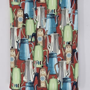 May include: A rectangular kitchen towel with a repeating pattern of vintage coffee pots in shades of green, blue, and silver on a red background. The towel has a white border.