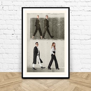 Puede incluir: Una impresi&oacute;n enmarcada que presenta cuatro figuras caminando en fila, vestidas con atuendos en blanco y negro. La impresi&oacute;n est&aacute; en un marco negro y se muestra contra una pared de ladrillos blancos. Las figuras est&aacute;n en una pose similar.