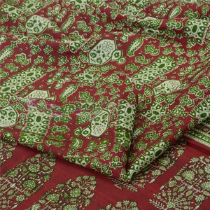 Pode incluir: Tecido vermelho com um padrão paisley verde e branco. O tecido está dobrado ao meio e o padrão é visível em ambos os lados.