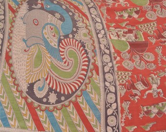 May include: A red and white fabric with a peacock design in the center. The peacock is surrounded by a border of green, blue, and yellow. The fabric is decorated with a variety of other designs, including flowers, leaves, and geometric patterns.