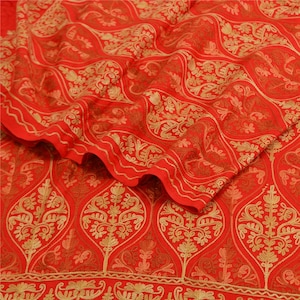 May include: Red fabric with a gold embroidered paisley pattern. The fabric is folded in half, showing the pattern on both sides.