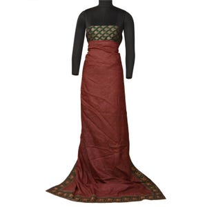 May include: A maroon floor-length dress with a patterned bodice and a flowing skirt. The bodice has a green and gold design. The hemline is trimmed with a decorative border. The dress is displayed on a black mannequin.