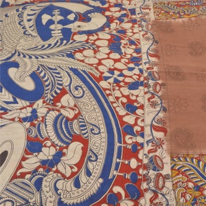May include: A traditional Indian saree with a colorful, intricate design featuring a peacock, floral motifs, and paisley patterns. The saree is made of a soft, lightweight fabric and is perfect for special occasions.