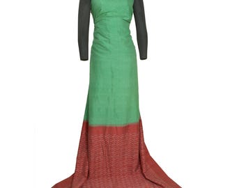 May include: A green and red formal gown with long black sleeves. The bodice is green, transitioning to a red skirt with a patterned hem. The dress has a high neckline and a flowing train.