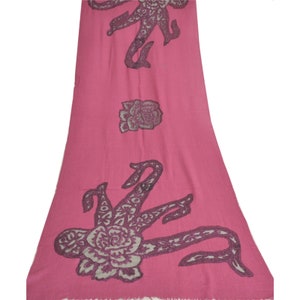 May include: A pink shawl with a floral design and a pattern of stylized animals. The shawl is made of a soft, lightweight fabric.