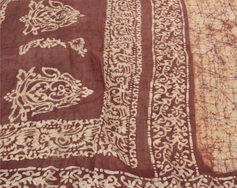 May include: A fabric textile featuring a deep brown background with cream-colored batik patterns. The design includes intricate floral motifs, decorative borders, and a section with a fine, web-like crackle texture in shades of brown and tan.
