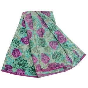 May include: A green and pink floral print fabric with a sheer texture. The fabric is folded in a circular shape.