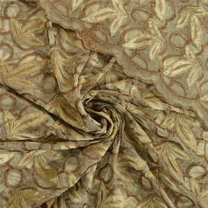 May include: A sheer fabric featuring an intricate embroidered leaf pattern in shades of tan and copper. The design includes scalloped edges and small, scattered bead accents throughout the mesh material, creating a textured, layered appearance.