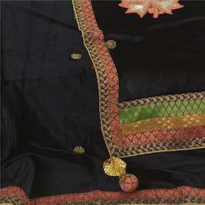Puede incluir: Chaleco de terciopelo negro con ribetes dorados y granates. El chal tiene un borla decorativa y detalles bordados.