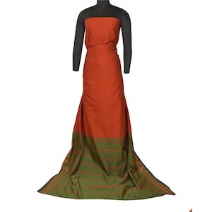 May include: A long, rust-colored fabric with a green border and thin stripes. The fabric is draped over a mannequin.