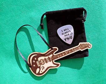 Adorno navideño con forma de guitarra grabada. Añade un recuerdo novedoso con forma de púa.