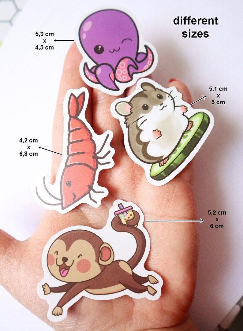 May include: Four different sized stickers featuring cartoon animals and objects. The stickers are on a hand. The stickers are: a purple octopus, a red shrimp, a brown hamster on a green watermelon slice, and a brown monkey holding a boba tea.