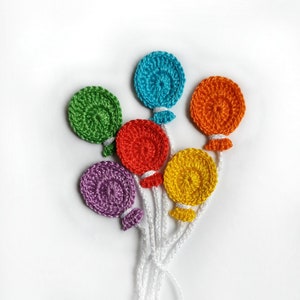 May include: A bunch of crocheted balloons in various colors, including purple, green, yellow, orange, and blue, with white strings.