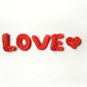 May include: The word "LOVE" spelled out in red crocheted letters with a red crocheted heart.