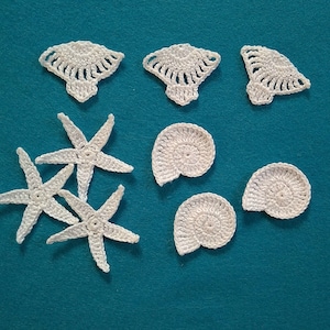 May include: A collection of white crocheted sea-themed decorations, including starfish and seashells, on a teal background.