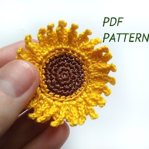 Puede incluir: Un girasol de ganchillo con un centro marrón y pétalos amarillos. PATRÓN PDF.