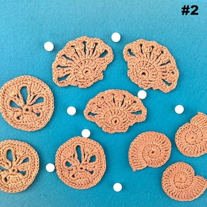 May include: A collection of handmade crochet seashell appliques in various shapes and sizes, including fan and spiral designs. The appliques are a light brown color and are arranged on a blue background with white accents.