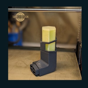 May include: A 3D printed black plastic holder for a hexagonal yellow inhaler. The holder has a TAPP3DDESIGN logo on it.