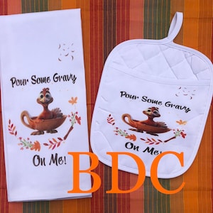 May include: White kitchen towel and pot holder set with a cartoon turkey graphic. The text on both items reads "Pour Some Gravy On Me!"