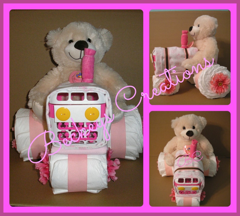 May include: A pink and white diaper cake shaped like a tractor with a teddy bear sitting in the driver's seat. The tractor has pink and white stripes and yellow wheels. The teddy bear is wearing a pink bow.