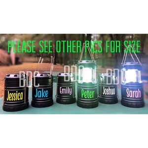 May include: Five black camping lanterns with different names on each: Jessica, Jake, Emily, Peter, and Sarah.  PLEASE SEE OTHER PICS FOR SIZE is written in green letters across the top of the image.
