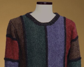 Könnte beinhalten: Ein gestreifter Pullover mit Rundhalsausschnitt. Der Pullover ist aus weichem, gestricktem Stoff gefertigt und in verschiedenen Farben gehalten, darunter Braun, Grün, Lila und Rot.