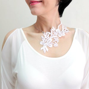Puede incluir: Collar gargantilla de encaje blanco con dise&ntilde;o floral. El collar es delicado e intrincado, con un patr&oacute;n fluido de hojas y flores.