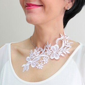 Puede incluir: Collar gargantilla de encaje blanco con un dise&ntilde;o floral. El collar es delicado e intrincado, con una variedad de flores y hojas.