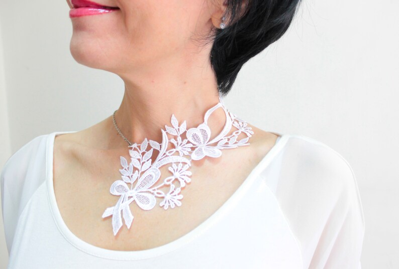 Puede incluir: Collar gargantilla de encaje blanco con dise&ntilde;o floral. El collar es delicado y femenino, y ser&iacute;a perfecto para una boda u otra ocasi&oacute;n especial.